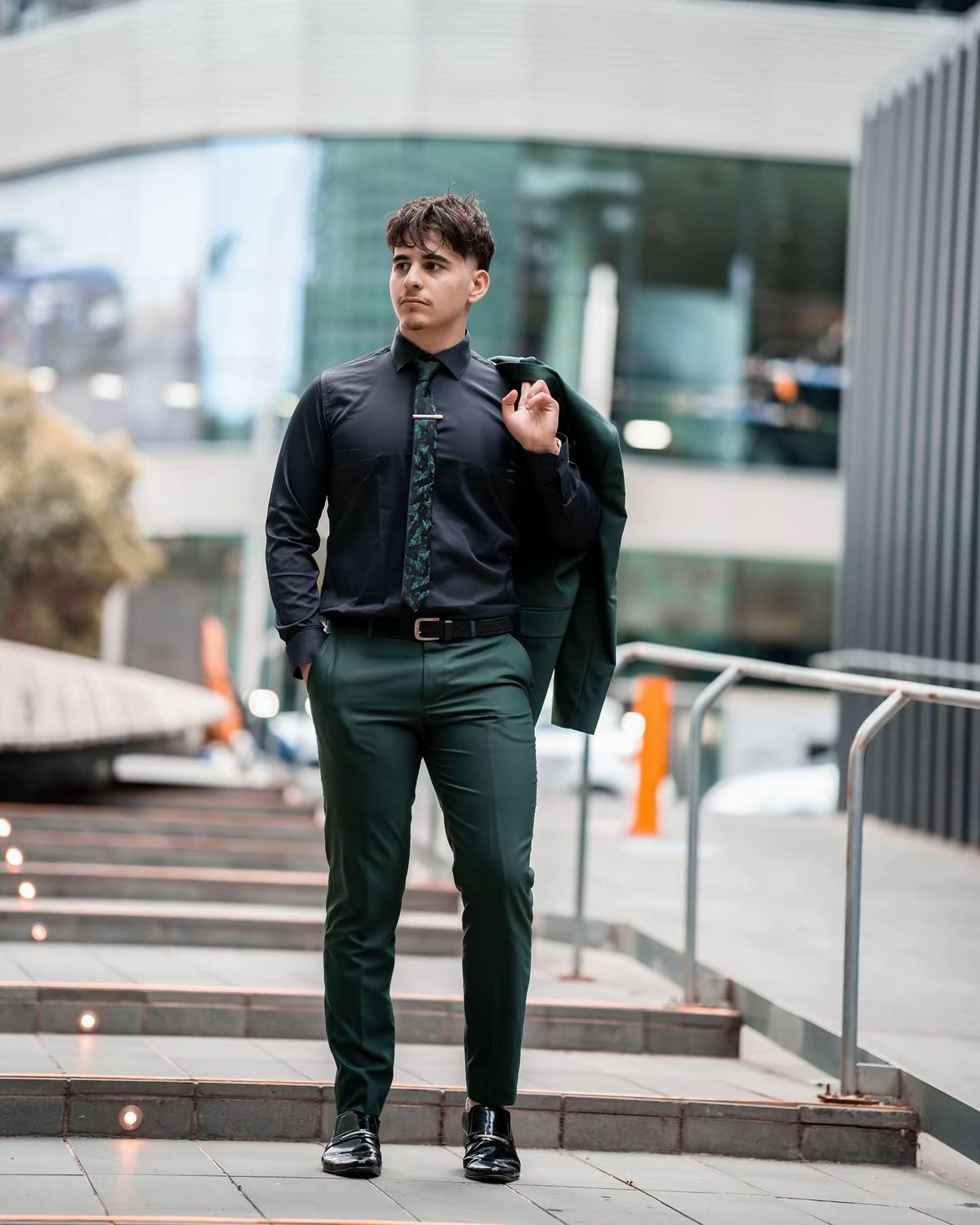 Mohsen Carter walking down city steps with a jacket over his shoulder